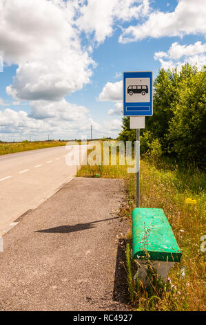 Old Fashion Bushaltestelle mit grün lackiert konkrete Sitzbank auf der Landstraße von ländlichen Natur, Felder und grünen Pflanzen umgeben Stockfoto