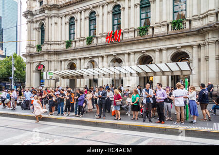 Melbourne, Australien - 21. Februar 2018: Die Menschen warten auf die Straßenbahn an der Bourke Street vor der Alten Post. Die Straße liegt im Herzen der Stockfoto