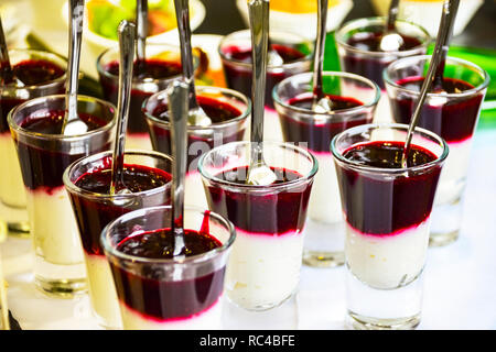 Catering Service Konzept: Berry Mousse Pudding Parfait Im Glas Schüsse mit Löffeln zu einem Business Event, Hotel, Geburtstag oder Hochzeit Celebrati serviert. Stockfoto