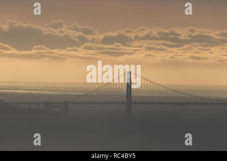 Die Golden Gate Bridge in San Francisco von weit weg in die Berkeley Hills bei einem wunderschönen Sonnenuntergang zu sehen, wenn der Himmel war orange. Stockfoto