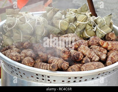 Chinesisch klebrigen Reis Knödel in den Blättern und Wurzeln in der dampfeinheit Taro gewickelt Stockfoto