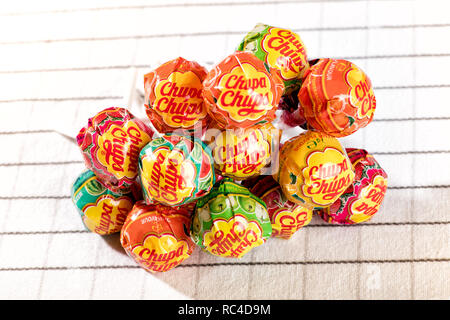 Stapel von Chupa Chups Lutscher Bonbons in der Nähe gesehen - bis auf weißem Stoff Tischdecke, von hohen Winkel Stockfoto