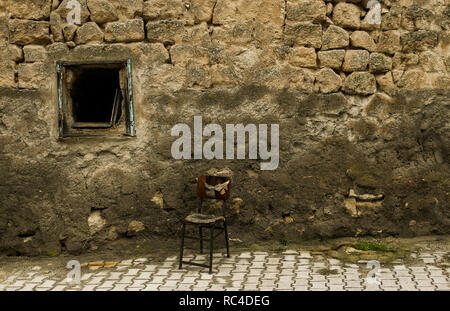 Alten Stuhl in der Straße vor dem Braun im Alter von Stein Wand des Hauses in Kappadokien Stockfoto