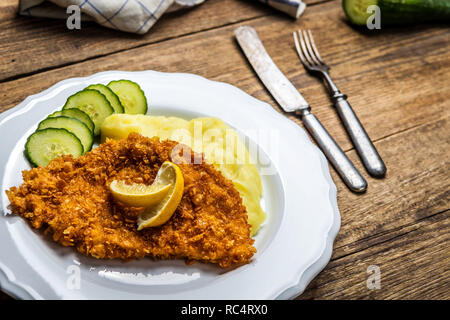 Huhn gebratenes Schnitzel mit Kartoffelbrei und Zitrone auf Holz Tisch Stockfoto