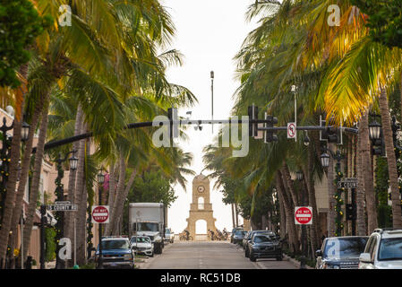 Palmen gesäumten Worth Avenue und Oceanfront Uhrturm mit frühen Morgen Radfahrer in Palm Beach, Florida. (USA) Stockfoto