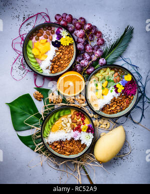 Smoothie Schüssel. Gesundes Frühstück. Frisches Müsli, Müsli mit Kokos, Banane und Muttern. Flach, Ansicht von oben, aus der Nähe. Stockfoto