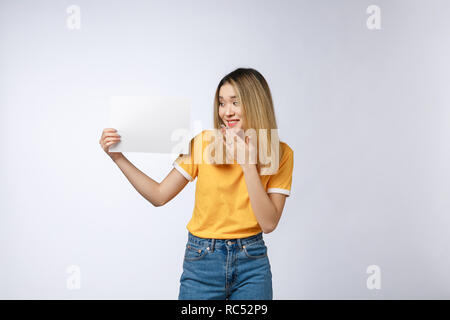 Banner anmelden Frau peeking über die Kante der Leere leere Papier Billboard mit Kopie Platz für Text. Schöne Asiatische kaukasische Frau überrascht und erschrocken - lustig. Auf weissem Hintergrund Stockfoto