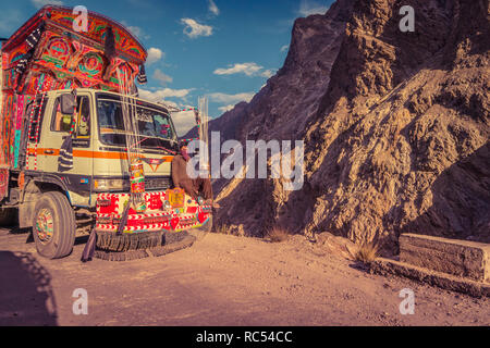 Karakorum Highway, Pakistan - 19. Juli 2018: Die pakistanischen Mann reisen auf den vorderen Stoßfänger von Dekorierten Lkw auf gefährliche Mountain Road. Illustrative e Stockfoto