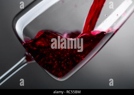 Rotwein in Glas Wein eingeschenkt. Stockfoto