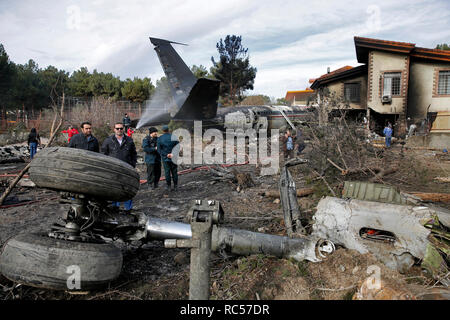 Dieses Bild von mizan Nachrichtenagentur, zeigt der iranische Rettungskräfte und Sicherheit arbeiten am Standort einer Boeing 707 Cargo Flugzeugabsturz, bei Fath Flughafen etwa 40 km (25 Meilen) westlich von Teheran, Iran, Montag, 14.01.2019. Ein Iranischer Emergency Management offizielle hat gesagt, TV mit 16 Menschen an Bord einer Boeing 707 Cargo Flugzeug, das westlich von Teheran abgestürzt ist und dass es nur eine einzige bekannte Überlebende waren. (Hasan Shirvani/Mizan Nachrichtenagentur über AP) Stockfoto