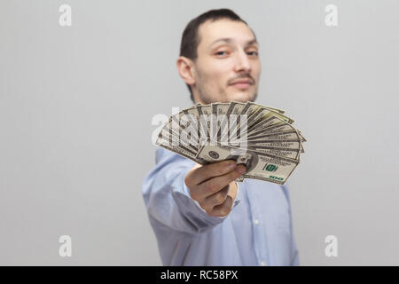 Es ist für Sie! Portrait von zufriedenen zuversichtlich attraktive junge Unternehmer im blauen Hemd stehen, angezeigt, sodass Sie Fan von Geld. Hallenbad, Stu Stockfoto