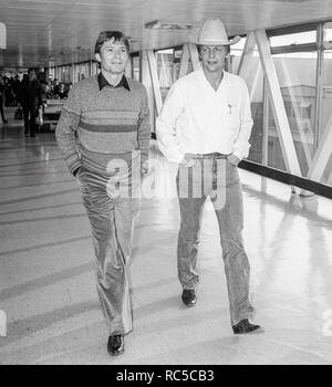 American Country Sänger John Denver und Schauspieler David Seele durch den Flughafen Heathrow reisen auf dem Weg nach Los Angeles, Februar 1984. Stockfoto