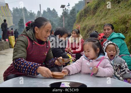 Provinz Guizhou, China - ca. Dezember 2018: Frauen und Kinder von Dong, Miao und Shui ethnischen Gruppen während der Hochzeitsfeier. Stockfoto