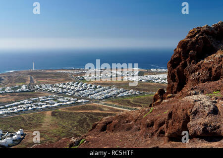 Blick in Richtung Playa Blanca und Faro de Pechiguera Leuchtturm, vom Gipfel der Montana Roja, Playa Blanca, Lanzarote, Kanarische Inseln, Spanien. Stockfoto