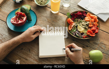 Man macht eine Liste der gesunden Lebensmittel. Gesunder Lebensstil Ernährung Food Konzept Stockfoto