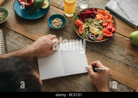 Man macht eine Liste der gesunden Lebensmittel. Gesunder Lebensstil Ernährung Food Konzept Stockfoto