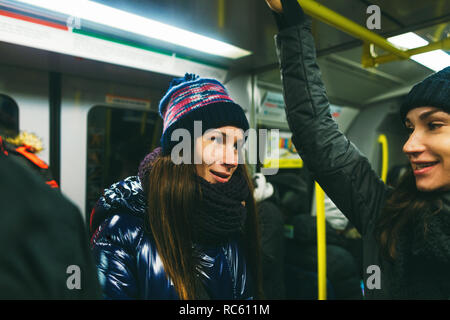 Zwei junge Frauen, Freundinnen im Gespräch in der U-Bahn in Stockholm, Schweden Stockfoto