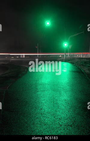 Ampel zeigt Grün in feuchten Nacht. Stockfoto