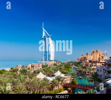 Blick auf Luxus Resort Hotels im Madinat Jumeirah, Burj Al Arab Hotel bis zu hinteren in Dubai in den Vereinigten Arabischen Emiraten Stockfoto