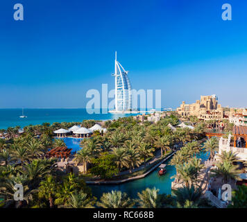 Blick auf Luxus Resort Hotels im Madinat Jumeirah, Burj Al Arab Hotel bis zu hinteren in Dubai in den Vereinigten Arabischen Emiraten Stockfoto