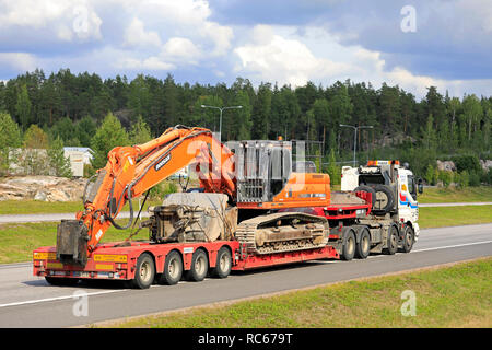 Paimio, Finnland - 31. August 2018: Weiße Sisu 18 E 630 Lkw von O. Rinne Oy hols Doosan DX 42 LC große Raupenbagger am Anhänger auf der Autobahn im Sommer. Stockfoto