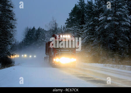 Salo, Finnland - Dezember 21, 2018: Fernlicht leuchtet der rote Scania V8 superdump Fahrzeug auf Landstraße auf einem blauen Winterabend in Finnland. Stockfoto