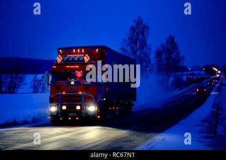 Salo, Finnland - Dezember 21, 2018: Schön angepasste rote Scania Auflieger von VR Rantanen Transporte laden auf der Autobahn auf einem blauen winter Abend. Stockfoto