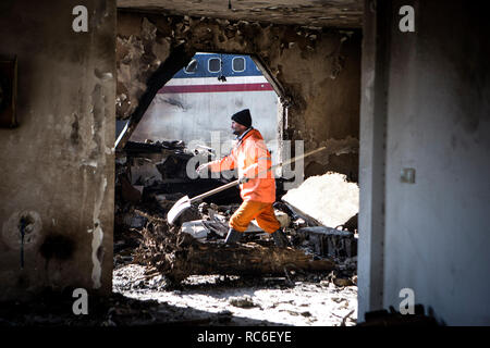 Karaj, Iran. 14 Jan, 2019. Ein Retter arbeitet an der Absturzstelle einer Boeing 707 Flugzeug in Karaj, Iran, 14.01.2019. Mindestens 15 Menschen wurden am Montag in der Absturz getötet. Credit: Ahmad Halabisaz/Xinhua/Alamy leben Nachrichten Stockfoto