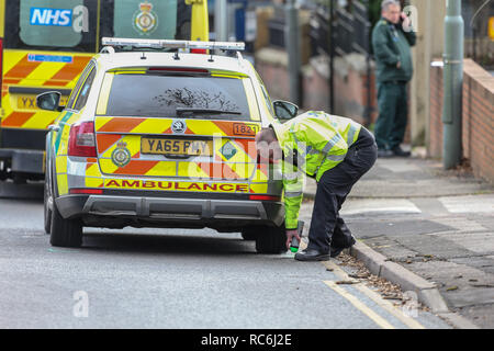 Pitsmoor, Sheffield, UK. 14. Januar 2019, Burngreave Straße, Pitsmoor, Sheffield, England; Buchse in einem ernsten Zustand nach einer Kollision mit einem Rettungswagen auf Burngreave Straße Pitsmoor Sheffield; eine Kollision investigator markiert den anhaltepunkt von der Notarzt Krankenwagen, das an der Kollision beteiligt: Kredit News Images/Alamy leben Nachrichten Stockfoto