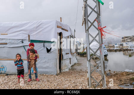 Januar 13, 2019 - Libanon - die Temperaturen sinken, Flüchtlinge vorbereiten für ein anderes nach den Schäden und Überschwemmungen durch Sturm Norma unleashed Sturm. Eine Familie beobachtete, wie Organisationen Beihilfen verteilen.. Storm Norma betroffen Tausende von syrischen Flüchtlinge leben in prekären Bedingungen in der Libanesischen Bekaa-tal. Sie sind jetzt gezwungen, die für eine andere Sturm, die sich vorbereitet werden. (Bild: © adib Chowdhury/SOPA Bilder über ZUMA Draht) Stockfoto