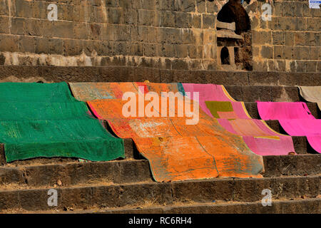 Bunte Teppiche und Decken am Ufer des Krishna und des Flusses Venna, in der Nähe des Dakshi Kashi Shiv Tempels, Mahuli Sangam, Maharashtra, Indien Stockfoto