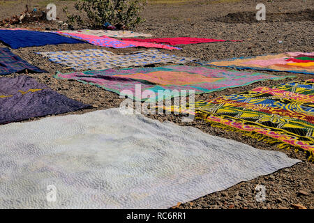 Bunte Teppiche und Decken am Ufer des Krishna und des Flusses Venna, in der Nähe des Dakshi Kashi Shiv Tempels, Mahuli Sangam, Maharashtra, Indien Stockfoto