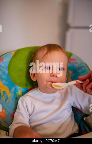 Cute Baby Boy genießt beim Essen in der Küche Stockfoto