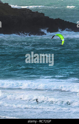 Ein einsamer kiteboarder Kitesurfen in rauer See bei Crantock Bach in Newquay Cornwall. Stockfoto