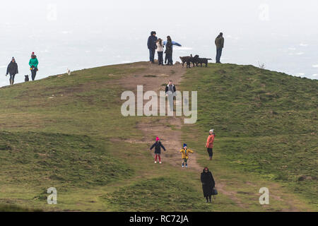 Menschen zu Fuß auf und steht auf den Überresten einer historischen Hügelgrab auf dem Gipfel des Pentire Point East in Newquay Cornwall. Stockfoto