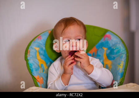 Lächelnd unordentlich Baby essen mag Stockfoto