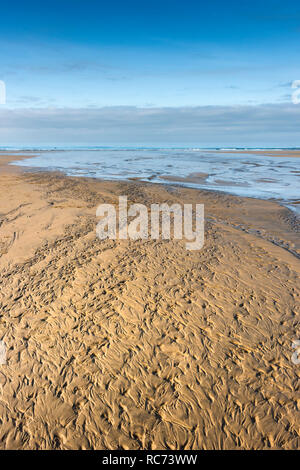 Wellen und Muster in den Sand am Strand bei Ebbe. Stockfoto