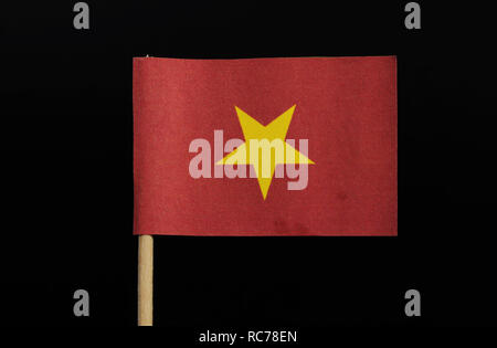 Eine offizielle Flagge von Vietnam auf Zahnstocher auf schwarzem Hintergrund. Ein grosser gelber Stern auf rotem Feld zentriert. Stockfoto