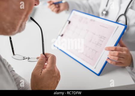 ältere Menschen und Arzt mit EKG im Krankenhaus Stockfoto