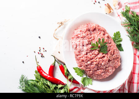 Hackfleisch mit Zutaten zum Kochen auf weißer Tisch. Ansicht von oben mit der Kopie. Stockfoto