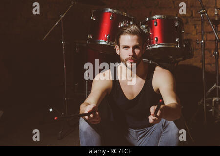 Ich Sticks. Man Drummer mit Trommelstöcken Instrument. Schöner Mann sitzen auf der Bühne am Schlagzeug. Rock Star oder Rocker. Genießen Instrumentalmusik. Rock Konzert oder Probe im Music Club Stockfoto