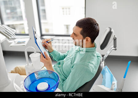 Patienten ausfüllen Antragsformular bei der zahnmedizinischen Klinik Stockfoto
