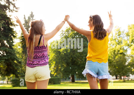 Mädchen im Teenageralter, Frieden hand Zeichen im Park Stockfoto