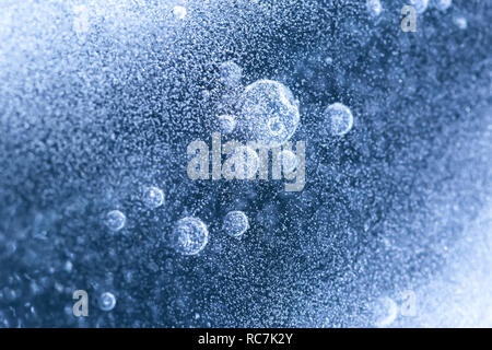 Luftblasen im Eis eingeschlossen. Luftblasen auf der Wasseroberfläche. Stockfoto