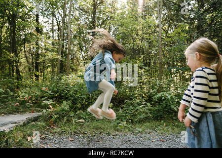 Schwestern spielen im Wald Stockfoto