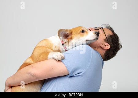 Erwachsene Mann halten corgi Hund Stockfoto