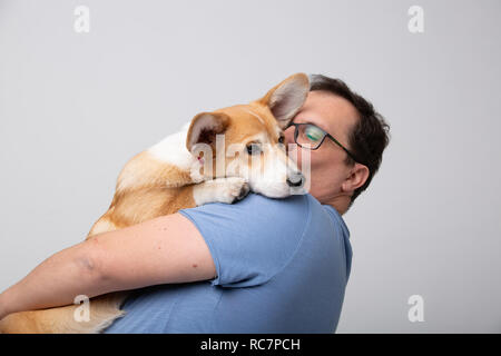 Erwachsene Mann halten corgi Hund Stockfoto