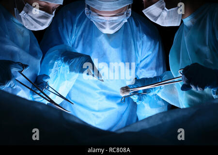 Gruppe von Chirurgen in Masken Ausführen des Vorgangs. Medizin, Chirurgie und Hilfe in Notfällen Konzepte Stockfoto
