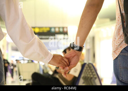 Hand in Hand gemeinsam in Terminal Flughafen auf der selektiven konzentrieren. Stockfoto