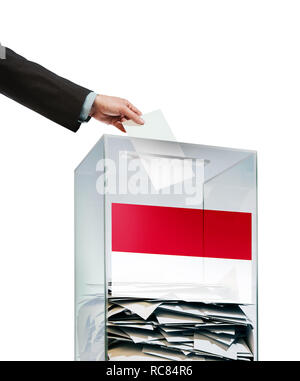 Hand einfügen Stimmzettel in klaren Wahlurne mit polnische Flagge. Stockfoto
